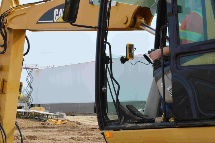 Spectra RD20 display mounted on the cab pillar of a CAT excavator, seen from outside